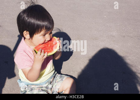 Little Boy mangiando anguria all'aperto Foto Stock