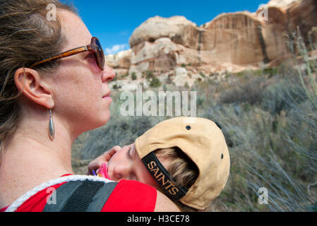 Madre escursionismo in natura, portante figlio che dorme Foto Stock