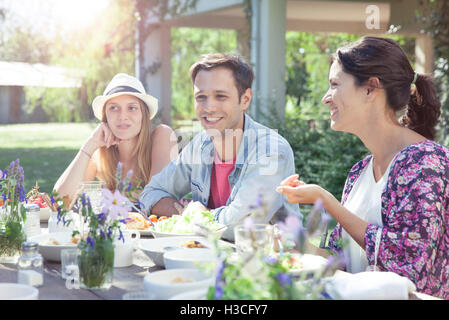 Amici in chat mentre godendo un sano pasto insieme Foto Stock