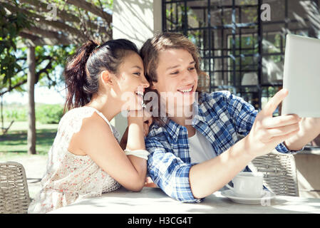 Coppia giovane tenendo selfie con tavoletta digitale Foto Stock