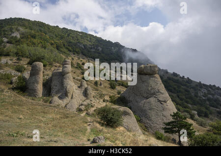 Nuvole basse sul pendio della montagna Demerdji. Le formazioni rocciose nella Valle dei fantasmi. Paesaggio di Crimea, Russia. L'Ucraina Foto Stock