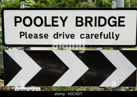 Cartello stradale attenzione agli automobilisti su entrata in POOLEY BRIDGE nel Lake District inglese Foto Stock