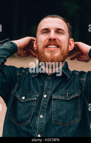 Bel uomo barbuto raddrizza i tuoi capelli Foto Stock