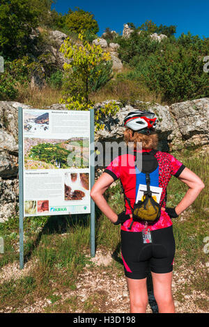 Visitatore la lettura di un segno interpretative a Manojlovac Falls, Parco Nazionale di Krka, Dalmazia, Croazia Foto Stock