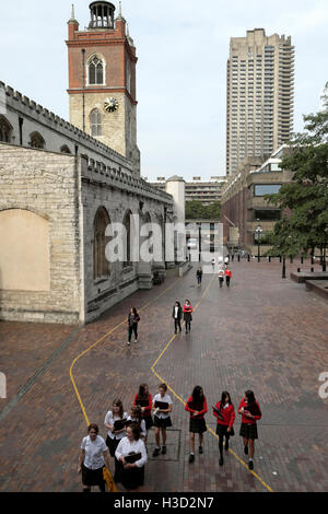 Un gruppo di studentesse di Londra in uniforme a piedi attraverso il cortile di San Giles chiesa nella città di Londra KATHY DEWITT Foto Stock