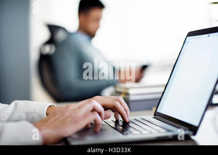 Immagine ritagliata dell uomo d affari con computer portatile in ufficio creativo Foto Stock