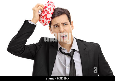 Giovane imprenditore con un mal di testa e la tenuta di un elemento refrigerante isolati su sfondo bianco Foto Stock