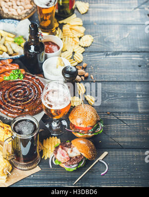 Oktoberfest, birra e snack impostato su sfondo scuro, spazio di copia Foto Stock