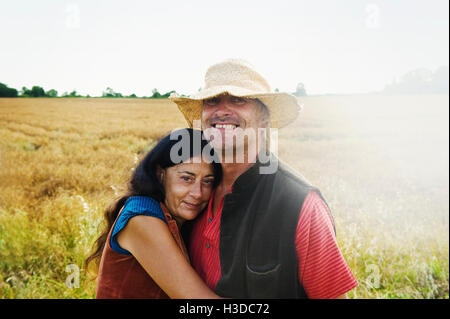 Un uomo e una donna si tengono per mano in un campo in estate. Foto Stock