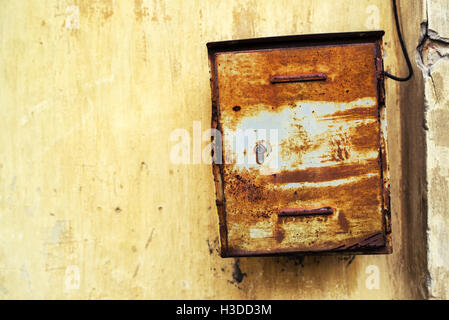 Vecchio arrugginito weathered mailbox sulla parete esterna Foto Stock