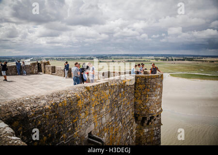 Le persone in visita a Mont Saint Michel monastero, Brittany, Francia godendo la vista dalla famosa isola comune Foto Stock