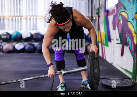 Un atleta femminile treni in una palestra crossfit. Foto Stock