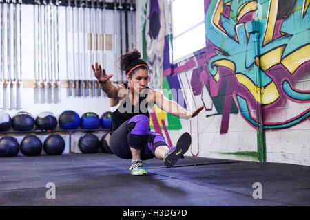 Un atleta femminile treni in una palestra crossfit. Foto Stock