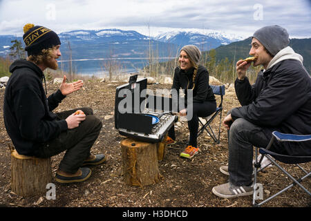 Gli amici di mangiare un pranzo di camp Foto Stock