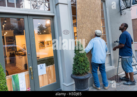 Charleston, Carolina del Sud. 5 Ottobre, 2016. Lavoratori la scheda Finestre di una galleria d'arte lungo Church Street in preparazione per l'uragano Matteo Ottobre 5, 2016 a Charleston, Carolina del Sud. L'uragano è previsto a testa lungo la costa vicino alla zona di Charleston e stato ordinato obbligatorio le evacuazioni di costa. Credito: Planetpix/Alamy Live News Foto Stock