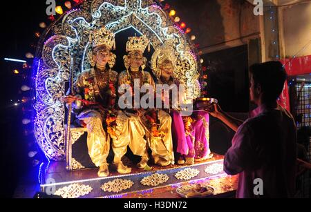 Di Allahabad, Uttar Pradesh, India. 6 Ottobre, 2016. Di Allahabad: un sacerdote offrono la preghiera di artisti indiani vestito come divinità Indù, da destra, Laxman, Sita e Rama, sedersi in un tableau durante un festival di Dussehra processione in Allahabad su 06-10-2016. Il festival celebra la vittoria del bene sul male. foto di rpabhat kumar verma Credito: Prabhat Kumar Verma/ZUMA filo/Alamy Live News Foto Stock