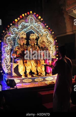 Di Allahabad, Uttar Pradesh, India. 6 Ottobre, 2016. Di Allahabad: un sacerdote offrono la preghiera di artisti indiani vestito come divinità Indù, da destra, Laxman, Sita e Rama, sedersi in un tableau durante un festival di Dussehra processione in Allahabad su 06-10-2016. Il festival celebra la vittoria del bene sul male. foto di prabhat kumar verma Credito: Prabhat Kumar Verma/ZUMA filo/Alamy Live News Foto Stock