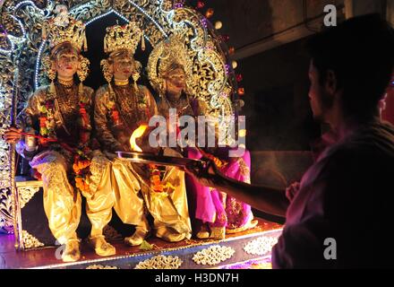 Di Allahabad, Uttar Pradesh, India. 6 Ottobre, 2016. Di Allahabad: un sacerdote offrono la preghiera di artisti indiani vestito come divinità Indù, da destra, Laxman, Sita e Rama, sedersi in un tableau durante un festival di Dussehra processione in Allahabad su 06-10-2016. Il festival celebra la vittoria del bene sul male. foto di rpabhat kumar verma Credito: Prabhat Kumar Verma/ZUMA filo/Alamy Live News Foto Stock