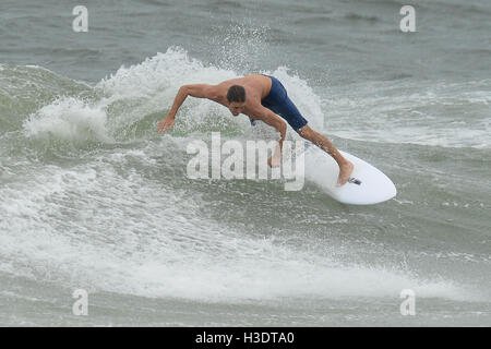 POMPANO Beach, FL - 06 ottobre: un surfista cavalcare le onde forniti dall uragano Matteo prima di influenzare Florida del sud il 6 ottobre 2016 in Pompano Beach , Florida. Credito: mpi04/MediaPunch Foto Stock