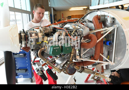 Schoenhagen, Germania. 07 ott 2016. Piano aria meccanico Felix Hennig lavora su un piano il motore presso la società Aquila GmbH in Schoenhagen, Germania, 07 ottobre 2016. La società produce un singolo motore di aeroplani di piccole dimensioni è in grado di consegnare il duecentesimo piano nella sua storia aziendale dopo essere stata acquisita dalla società turca BPLAS nel 2016 e la dichiarazione di fallimento nel 2015. Foto: Bernd Settnik/dpa/Alamy Live News Foto Stock