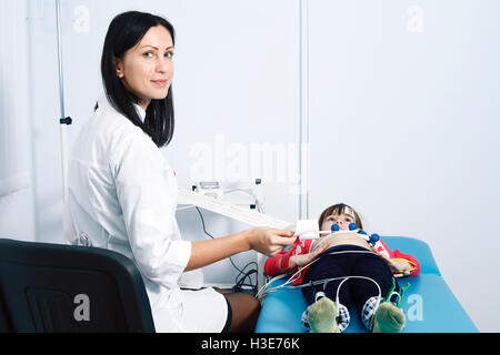 Una giovane donna medico cardiologo rende un sondaggio Foto Stock