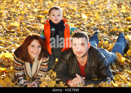 La famiglia felice passeggiate all'aperto, padre, madre e simpatici baby Foto Stock