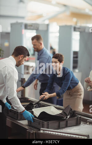 Raccolta dei " commuters " i loro sacchi dal contatore di sicurezza Foto Stock