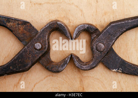 Un vecchio tenaglie vintage tool su un sfondo di legno Foto Stock