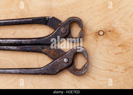 Un vecchio tenaglie vintage tool su un sfondo di legno Foto Stock