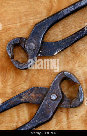 Un vecchio tenaglie vintage tool su un sfondo di legno Foto Stock