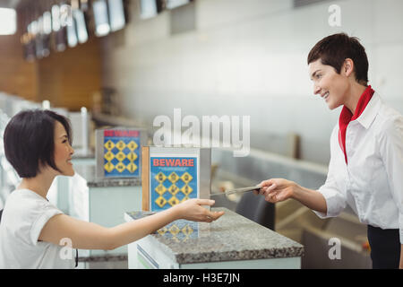 Compagnia aerea check-in attendant consegnando il passaporto per il passeggero Foto Stock