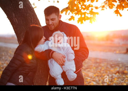 La famiglia felice passeggiate all'aperto, padre, madre e simpatici baby Foto Stock