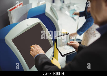 Imprenditore con servizio di self check-in macchina Foto Stock