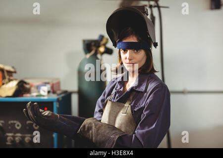 Ritratto di donna saldatore guanto da indossare Foto Stock