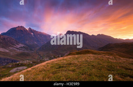 La luce del sole si colora all'alba. Plan du Lac; vallon de la Leisse et Vallon de la Rocheure. La montagna Grande casse. Parc National de la Vanoise. Francia. Europa. Foto Stock