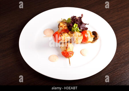 Un kebab di pollo su spiedini con pomodori Foto Stock