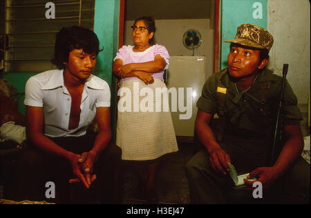 SAN SALVADOR EL SALVADOR, Marzo 1982 soldati controllare documenti di identità di un adolescente in una casa per casa ricerca. Foto Stock