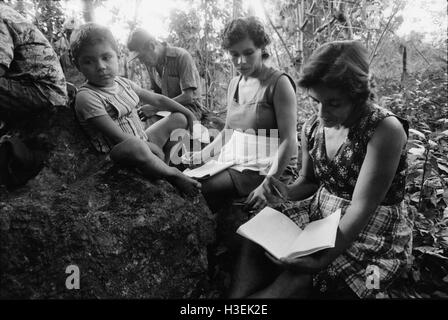 GUAZAPA, EL SALVADOR, FEB 1984: - all'interno del FPL Guerrilla zone di controllo - un livello di alfabetizzazione degli adulti classe svolgono ogni giorno sotto gli alberi per evitare di essere intercettata dal airforce. Foto Stock