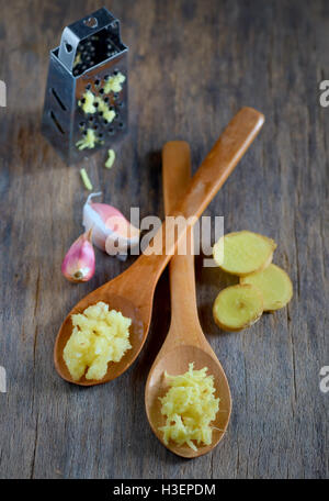 L'aglio e lo zenzero in cucchiai di legno sul tavolo di legno Foto Stock