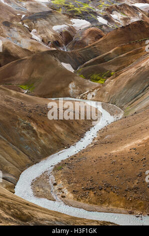 Fiume con il rosso delle colline e il rosso e il nero della lava montagne innevate in Kerlingarfjoll in Islanda. Foto Stock