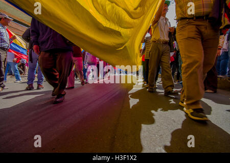 Street vista da sotto il gigante bandiera ecuadoriana durante il governo anti marzo e proteste in Quito Foto Stock