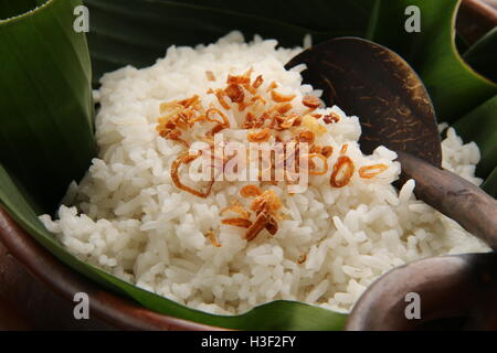 Nasi Uduk, tradizionale saporito piatto di riso da Betawi, Giacarta. Servita nella pentola di coccio rivestiti con foglia di banano. Foto Stock