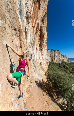 Stile Hippie scalatore femmina verticale ascendente Orange Rock Foto Stock