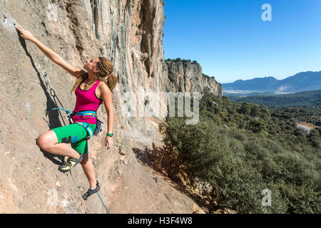 Stile Hippie scalatore femmina verticale ascendente Orange Rock Foto Stock