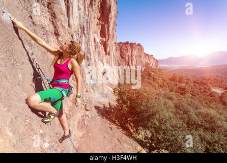 Stile Hippie scalatore femmina verticale ascendente Orange Rock Foto Stock