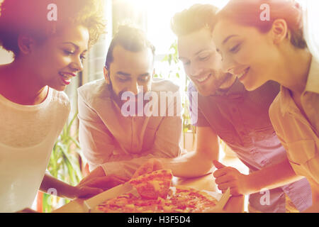 Happy business team di mangiare la pizza in ufficio Foto Stock