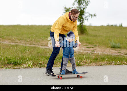 Felice padre e figlio su skateboard Foto Stock