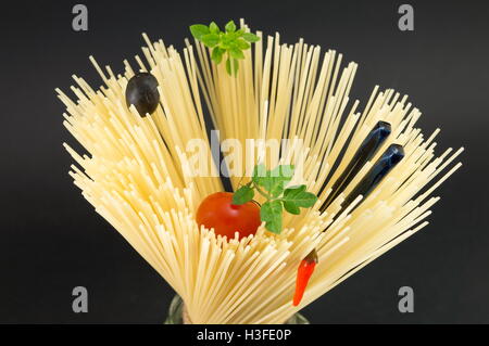 Materie spaghetti con pomodoro e olive poste in forma a spirale pronti per la cottura Foto Stock