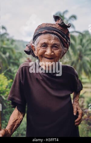 Ritratto della vecchia donna in piedi all'aperto e sorridente alla fotocamera. Senior femmina con uno splendido sorriso sul suo viso. Foto Stock