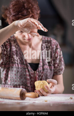 Stanco giovane donna fare una pasta nella sua cucina Foto Stock
